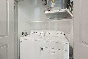 A white laundry room with two washes and a dryer